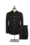 A navy blue men's safari jacket with gold buttons, displayed on a mannequin torso with matching navy trousers beside it. 
