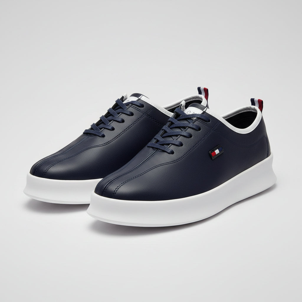 A pair of navy blue Tommy Hilfiger low-top sneakers with white soles, displayed with their branded boxes on a tabletop.